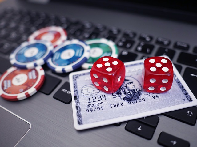 chips, a pair of dice, and a credit card on a laptop keyboard to portray the idea of online casino gaming
